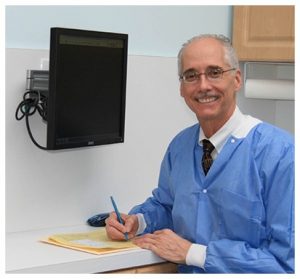 Dr. Douglas Deam smiling and working on papers